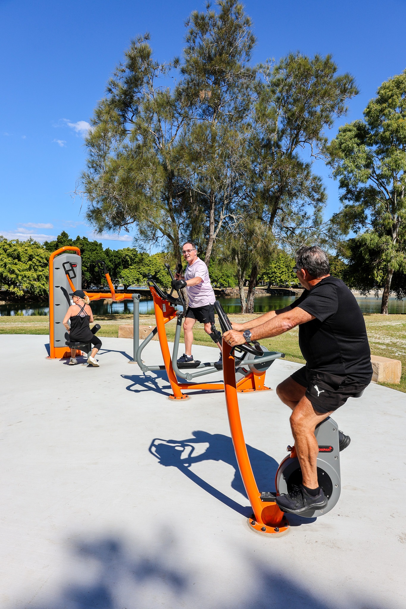 Group of people working out on KOMPAN outdoor gym equipment in the Gold Coast