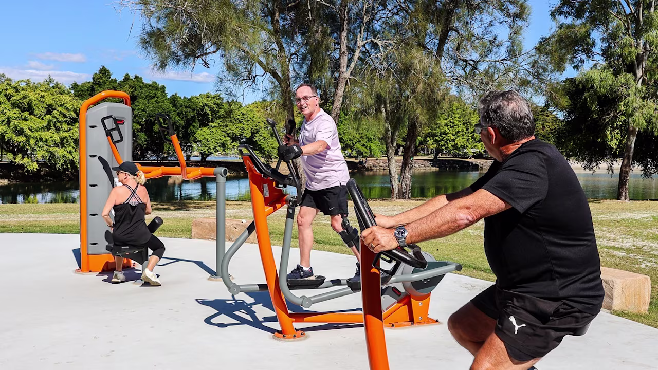Group of people working out on KOMPAN outdoor gym equipment in the Gold Coast