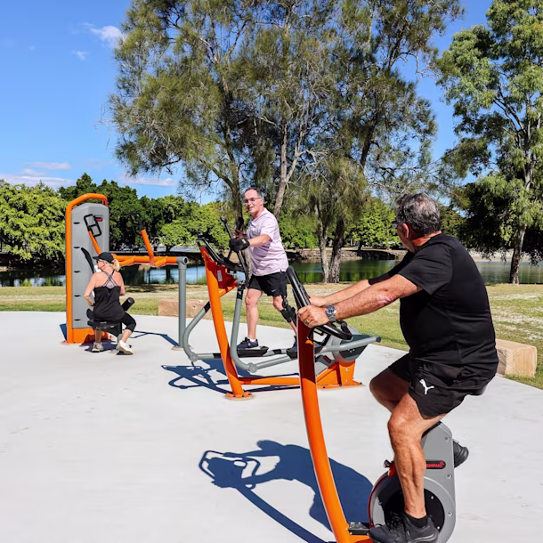Group of people working out on KOMPAN outdoor gym equipment in the Gold Coast