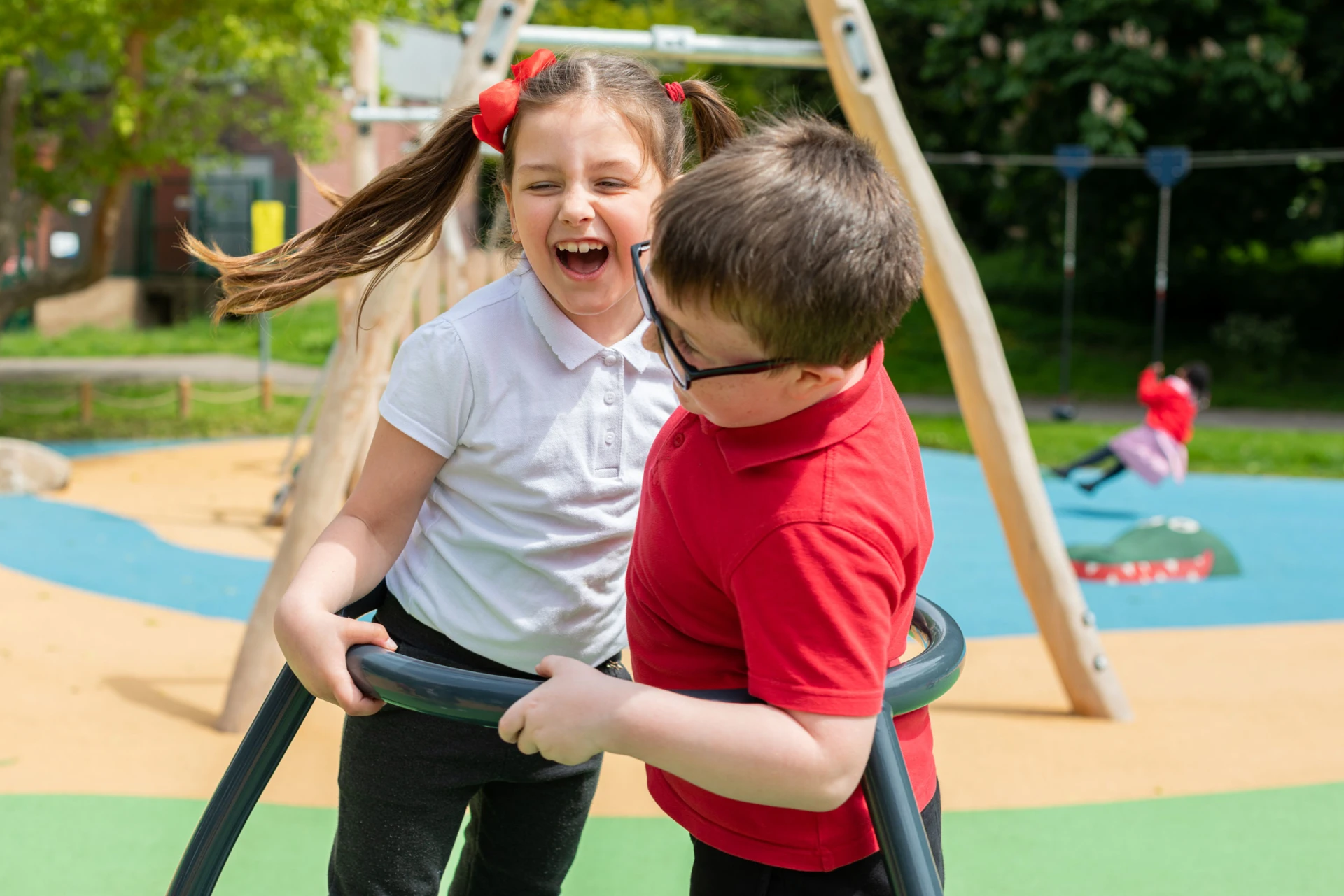 Un niño y una niña juegan en el carrusel de un parque infantil