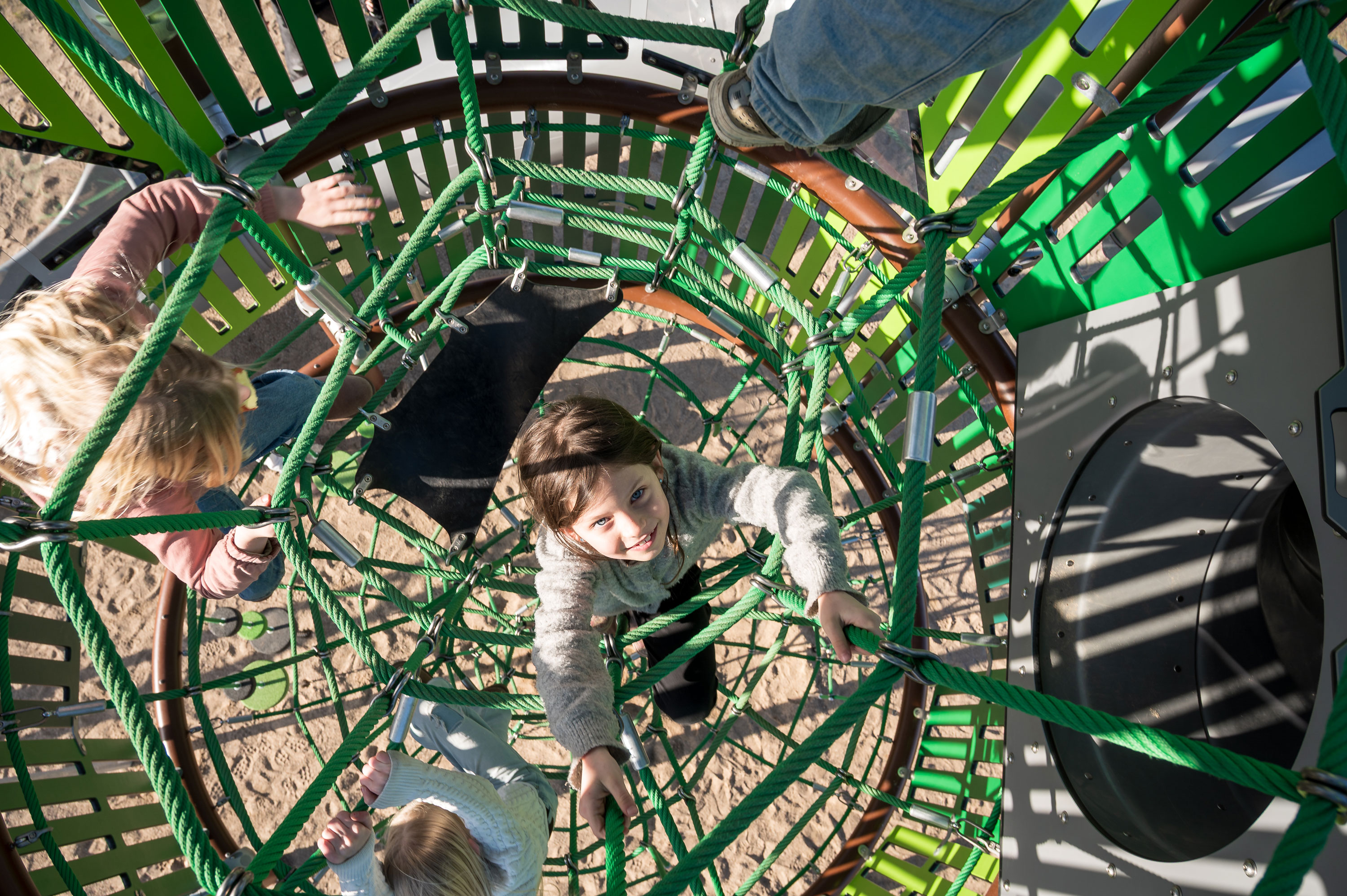 girls climbing inside a custom playground net tower. 