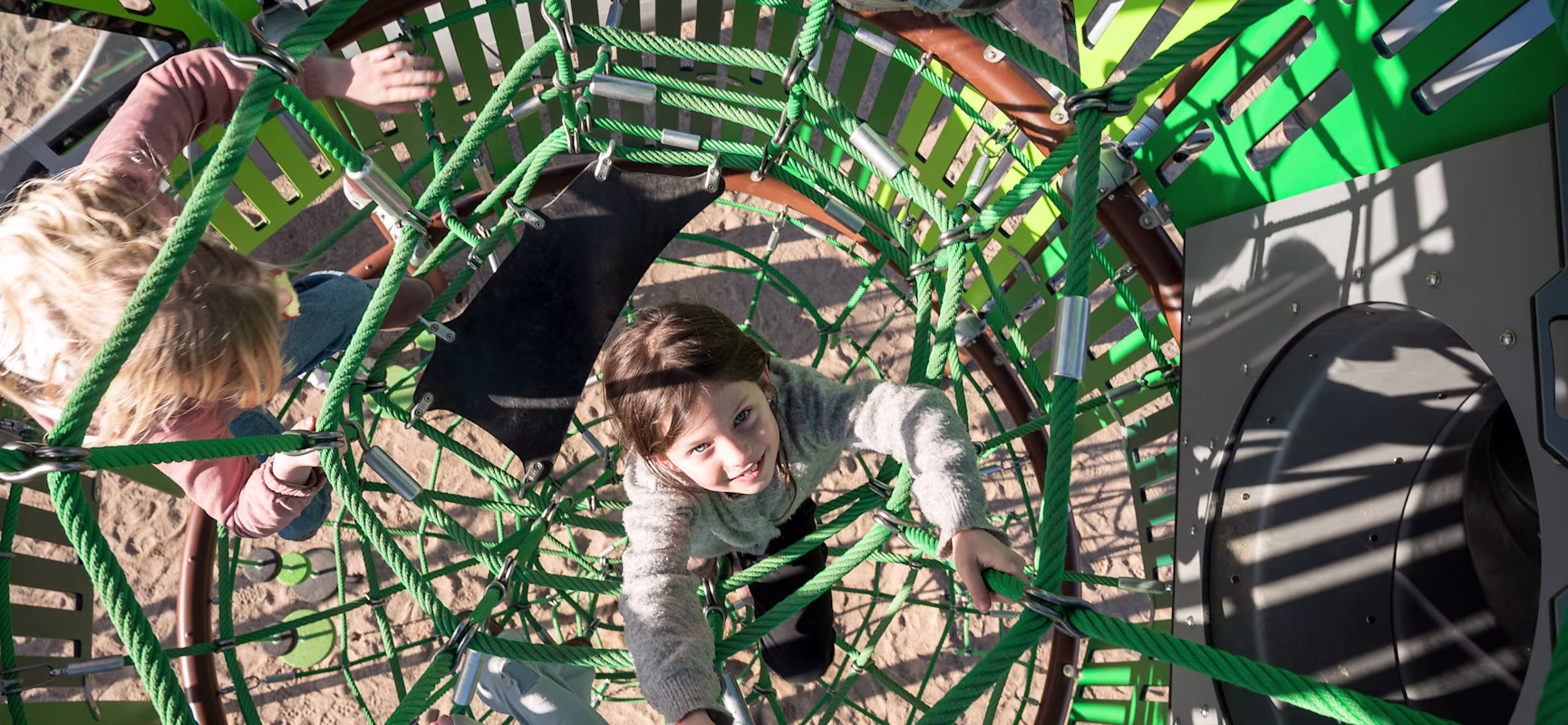 girls climbing inside a custom playground net tower.