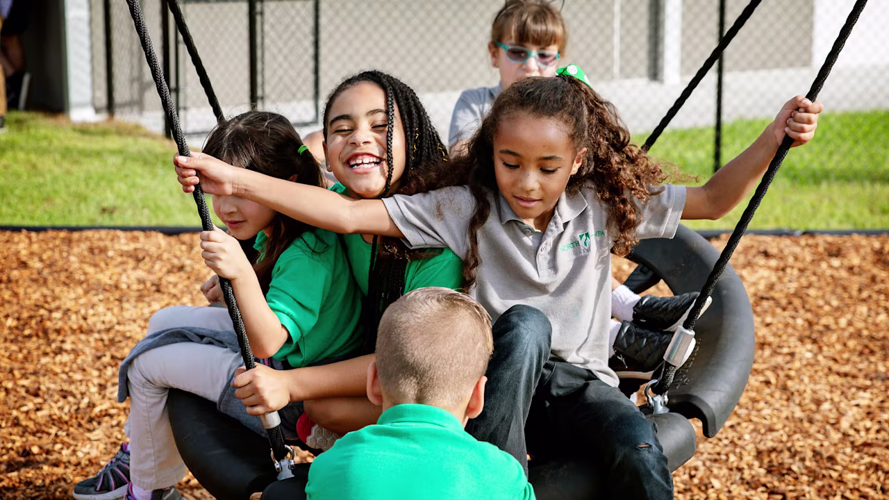 Children in school uniforms playing on a swing together