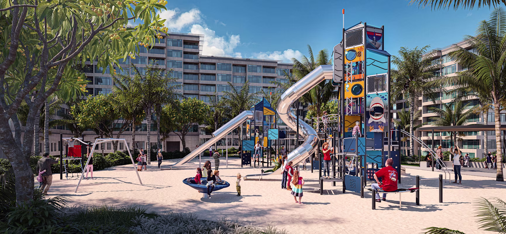 Children and adults play on colourful slides and climbing structures in a sunny sandy playground, with palm trees and apartments behind.
