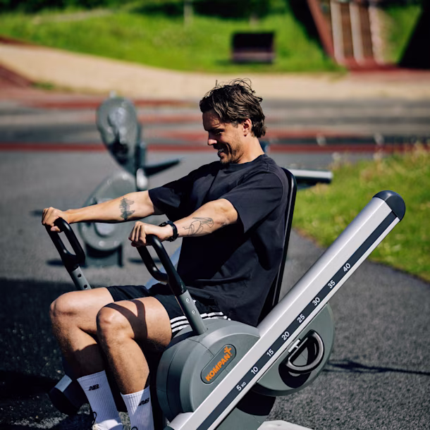 Un hombre haciendo ejercicio en una máquina de musculación al aire libre