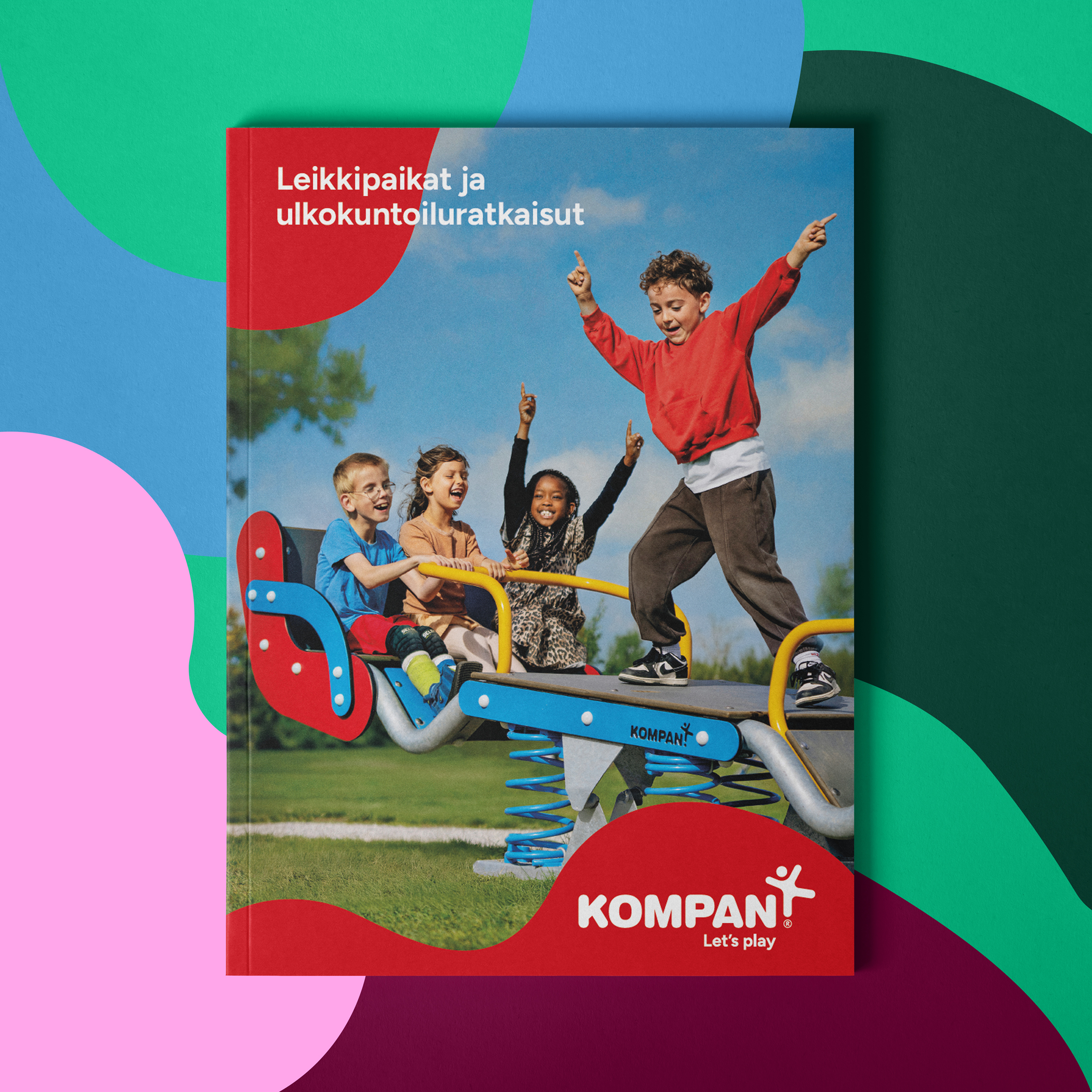 Cover of a Kompan playground catalog showing children playing on a colorful spring rocker in a park under a blue sky