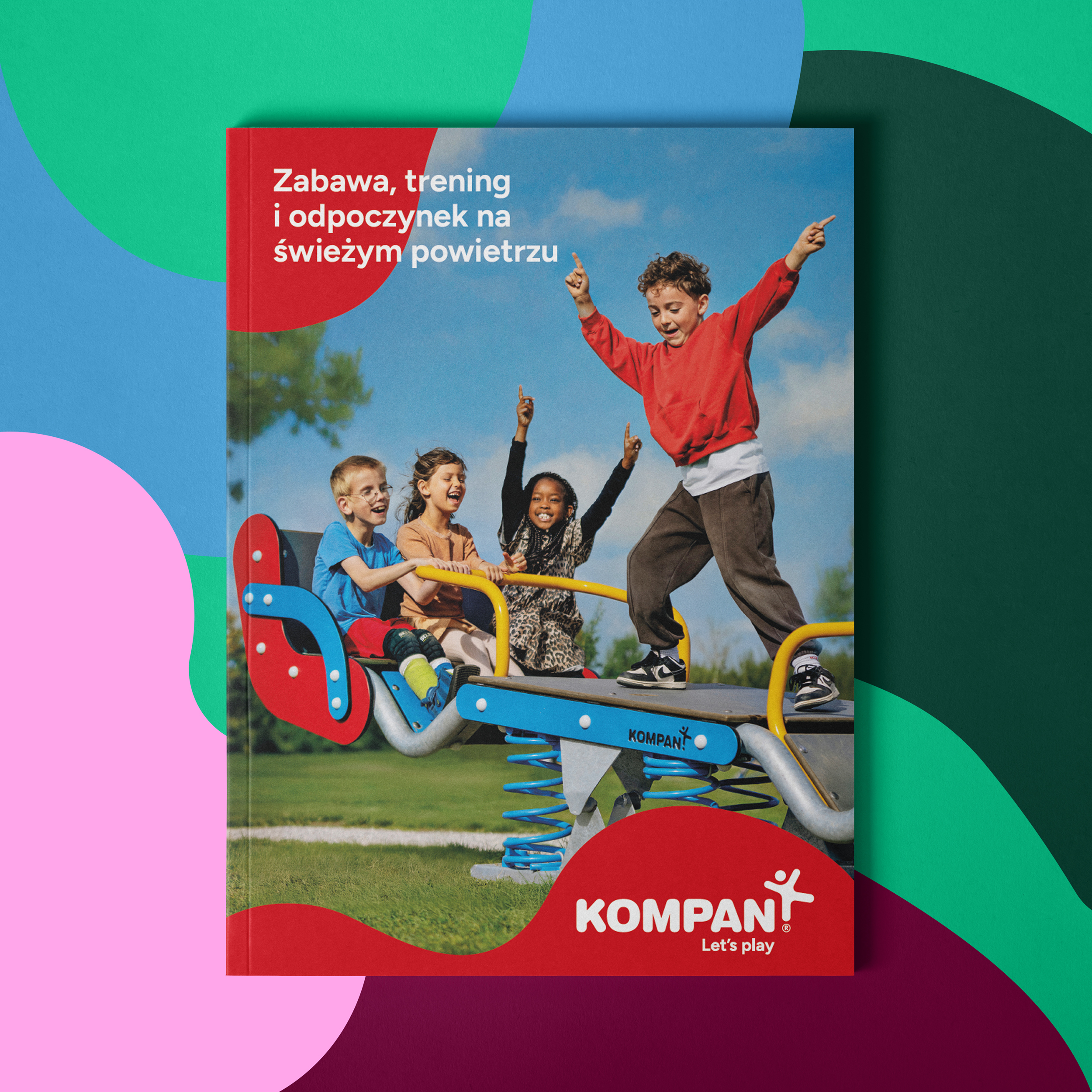 Cover of a Kompan playground catalog showing children playing on a colorful spring rocker in a park under a blue sky