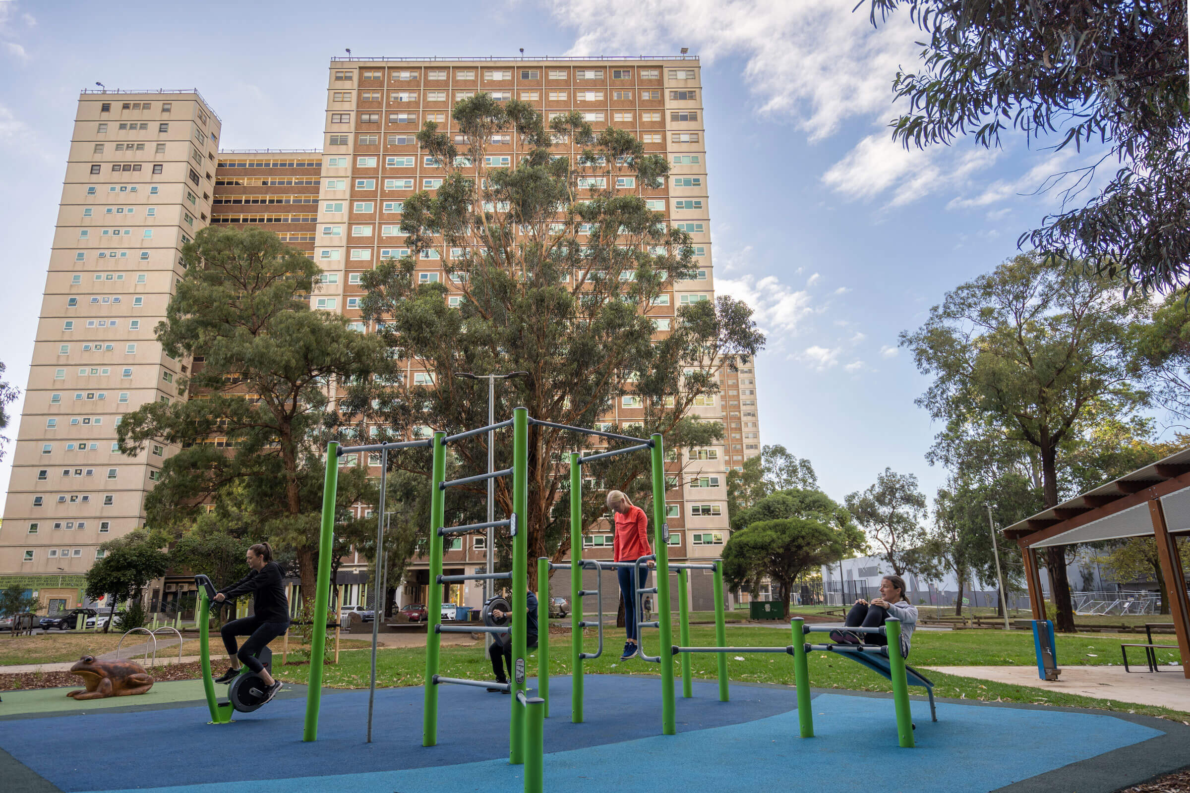 three men doing push ups on outdoor fitness equipment in wood
