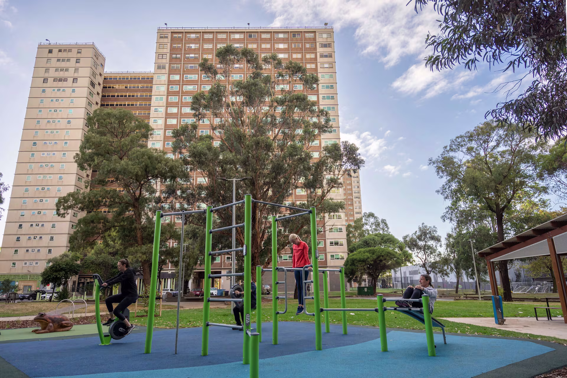 three men doing push ups on outdoor fitness equipment in wood