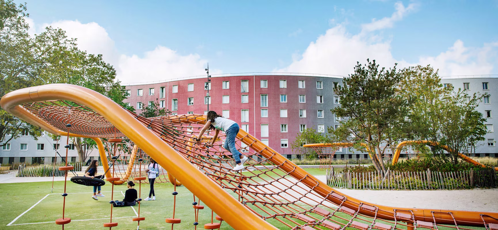 Children climbing on a large rope loop on Le Serpentin playground