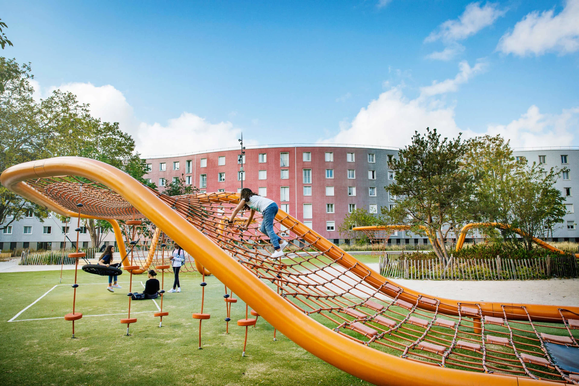 Children climbing on a large rope loop on Le Serpentin playground