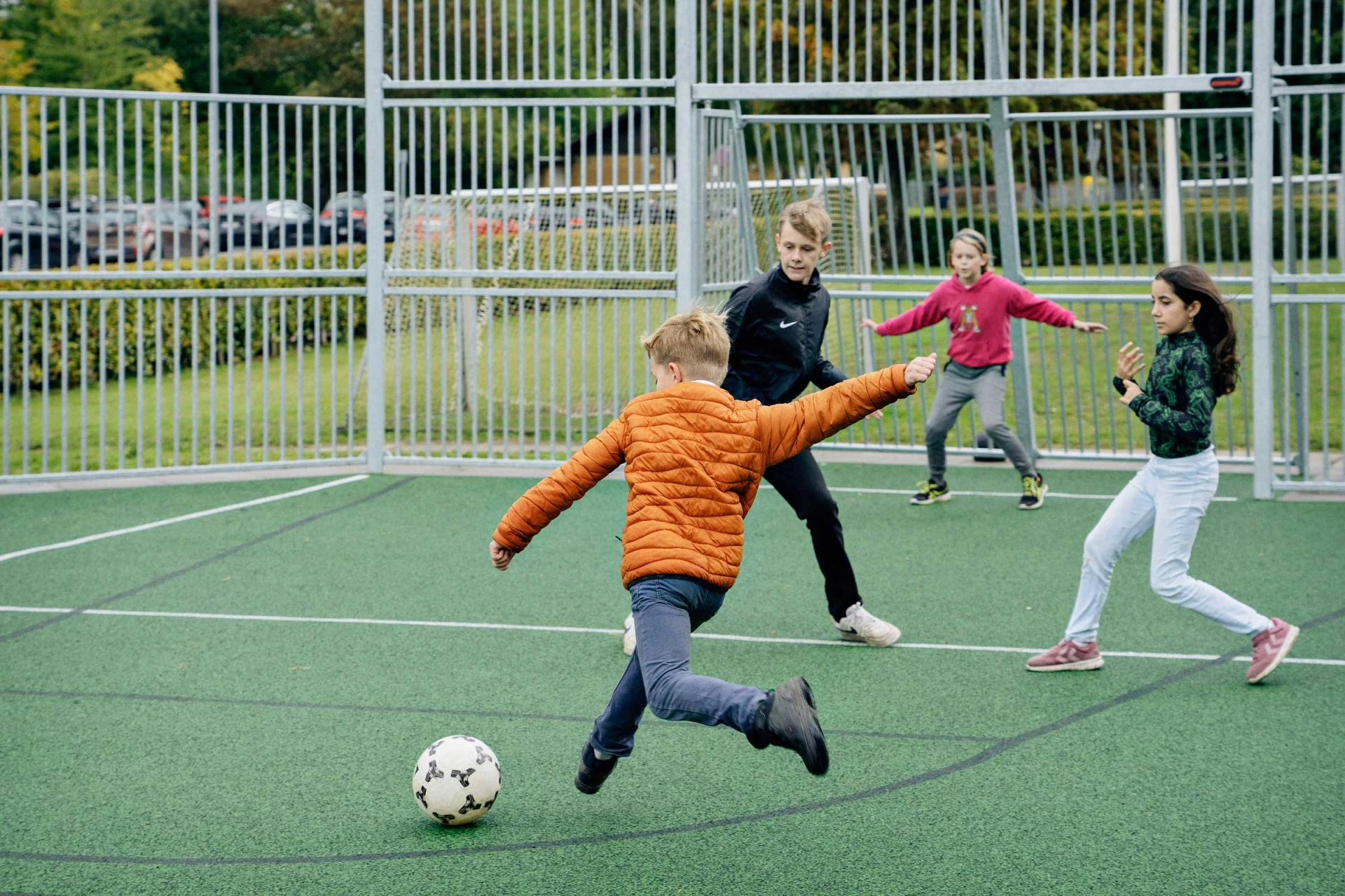 Pupils playing soccer at a multi use games area at Ebberup School