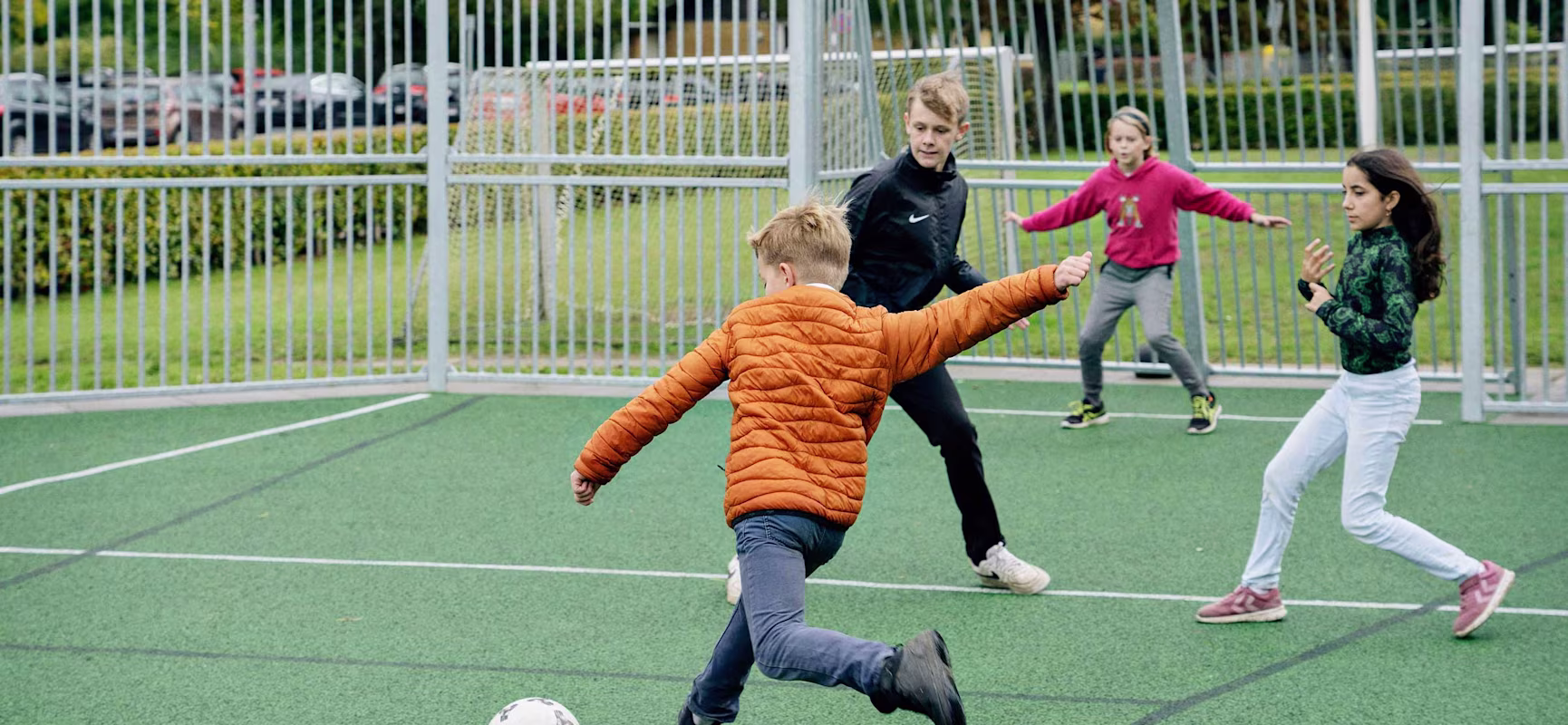 Pupils playing soccer at a multi use games area at Ebberup School