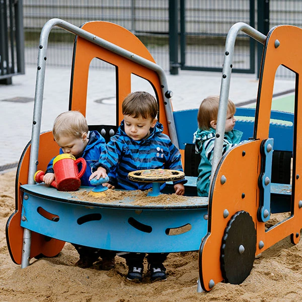 Vorschulkinder spielen auf einem Spielplatz mit Auto-Motiven