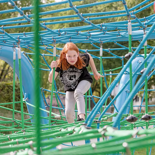Mädchen klettert in Corocord Seilspielgerät in Berlin, Deutschland