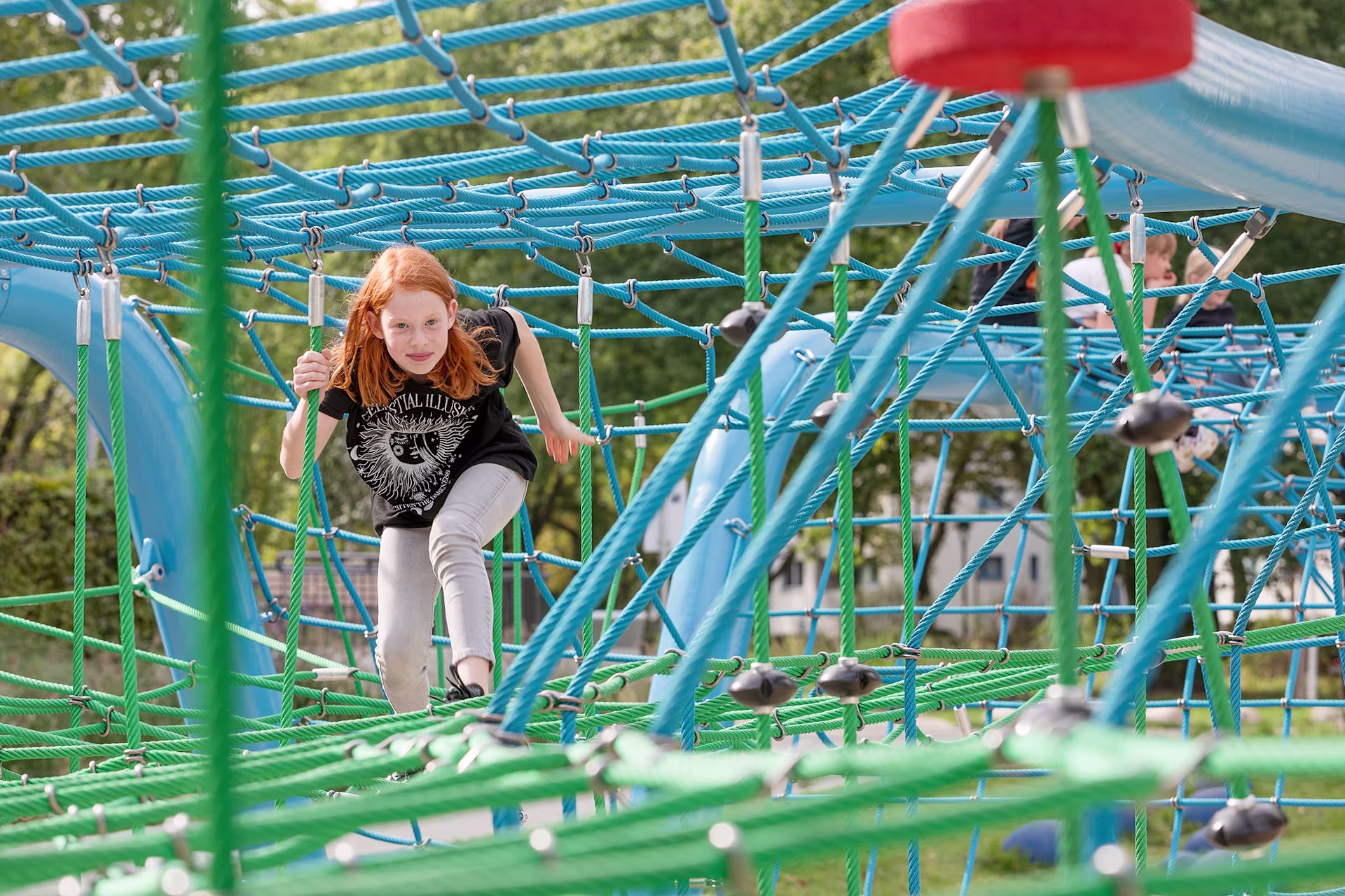 Mädchen klettert in Corocord Seilspielgerät in Berlin, Deutschland