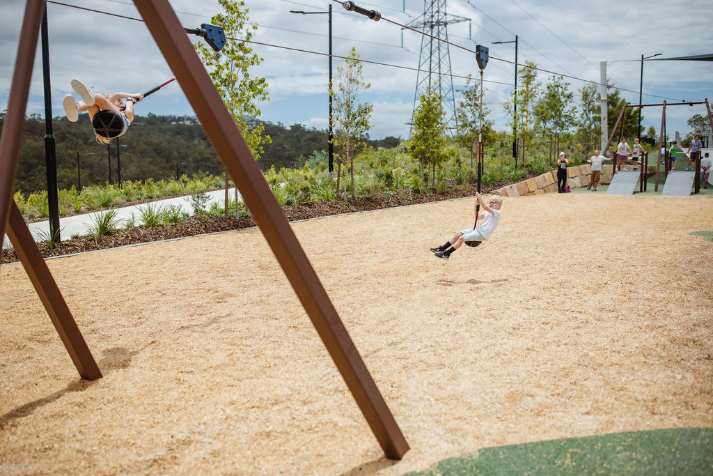 girl having fun on a playground zipline in a public park in England
