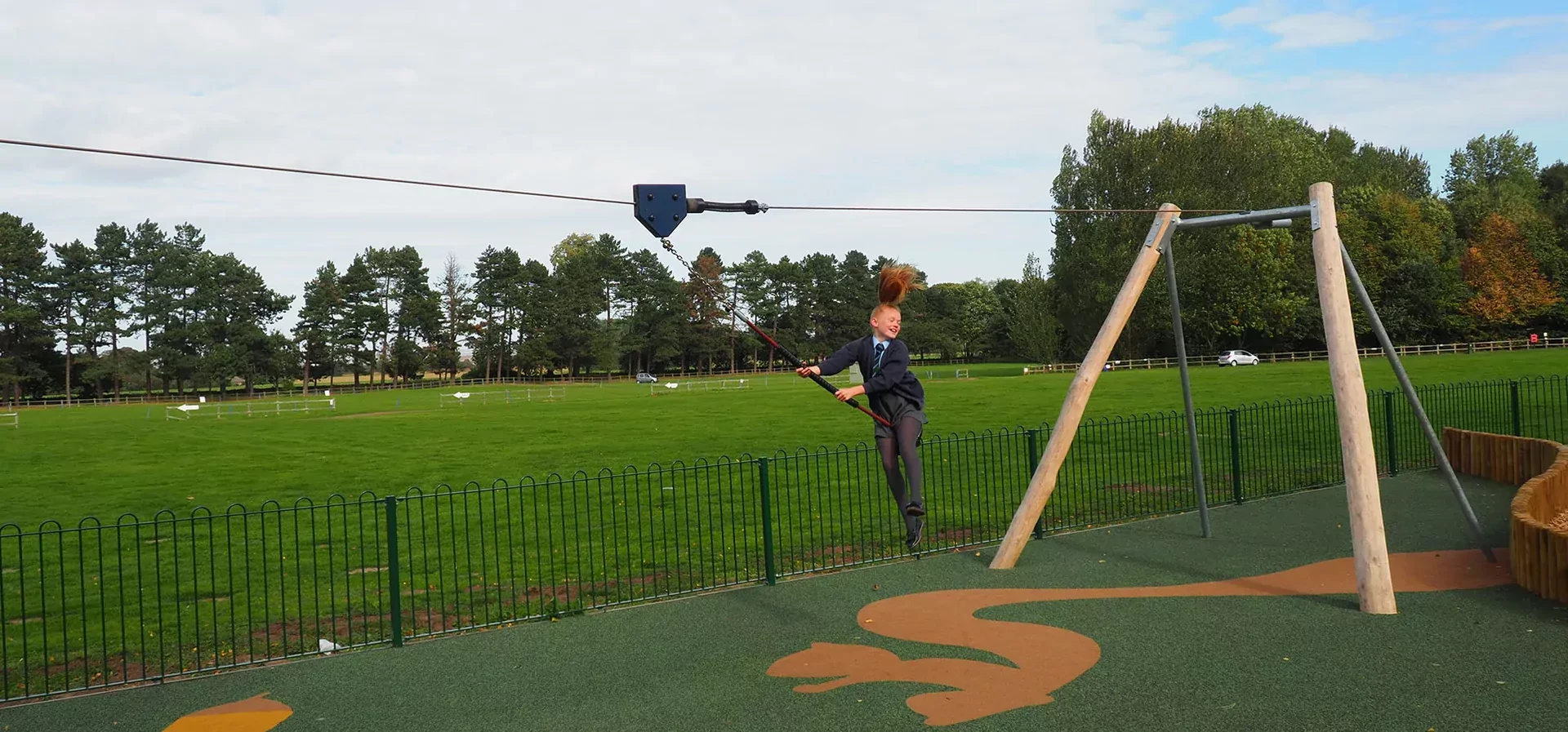 Mädchen hat Spaß auf einer Spielplatz Seilbahn in einem öffentlichen Park in England