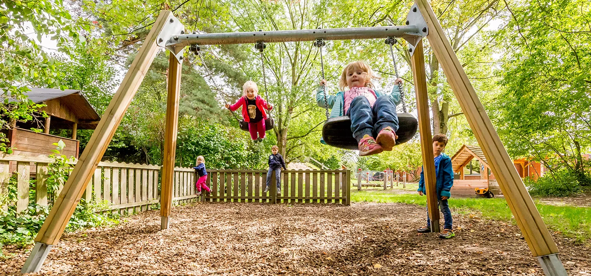 children on a classic playground equipment swing in a park