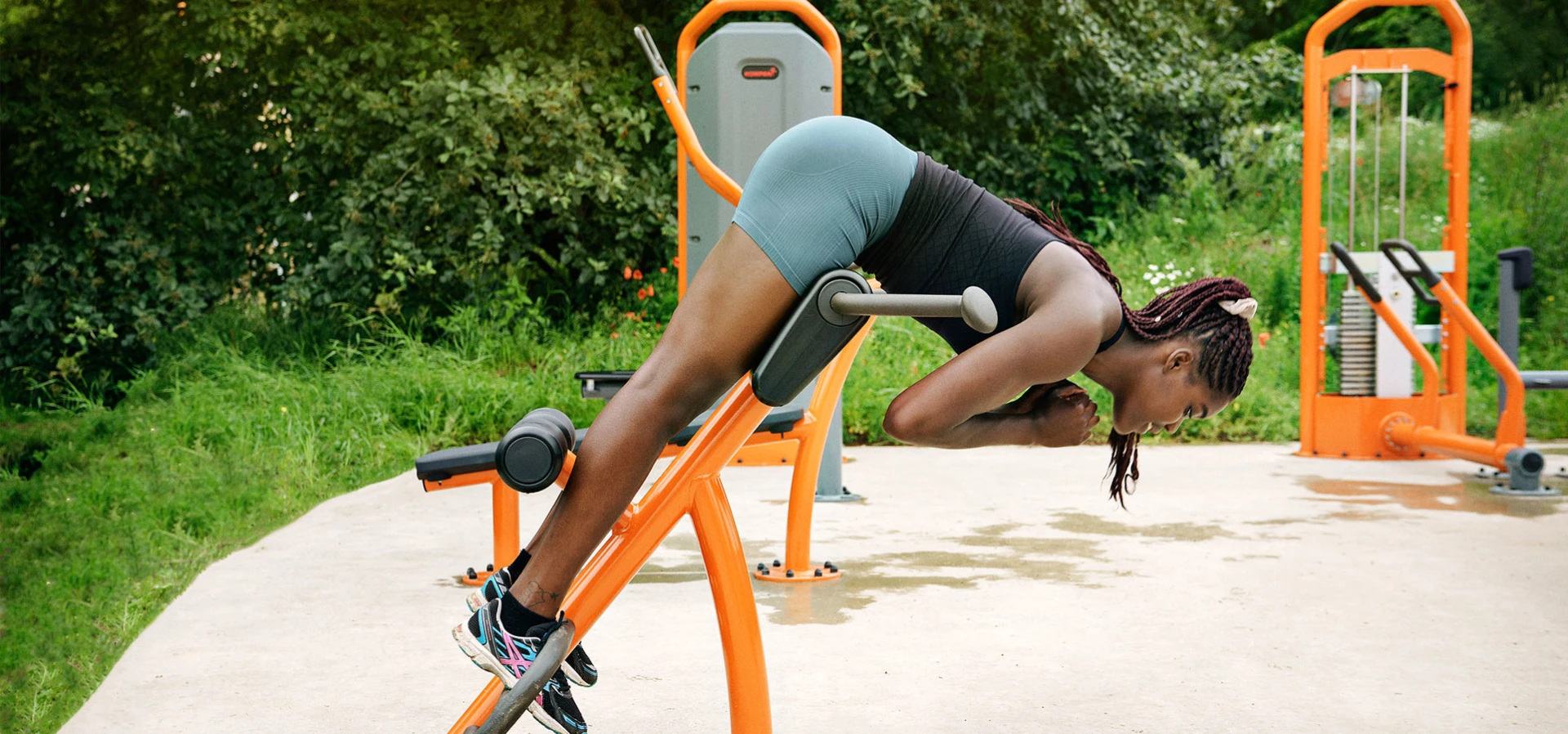 Woman using outdoor strength training machines for park gym 