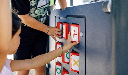 Children playing on a KOMPAN play panel, which is ground level for accessibility. Inclusive equipment is a key consideration for any playground construction project.