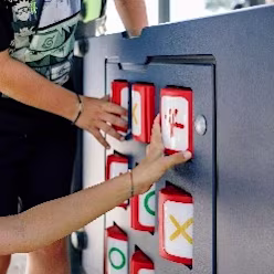Children playing on a KOMPAN play panel, which is ground level for accessibility. Inclusive equipment is a key consideration for any playground construction project.