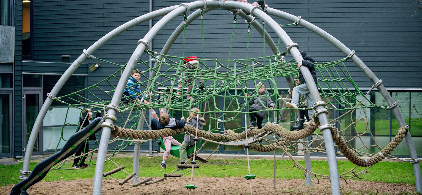 children playing on climbing dome in a schoolyard.