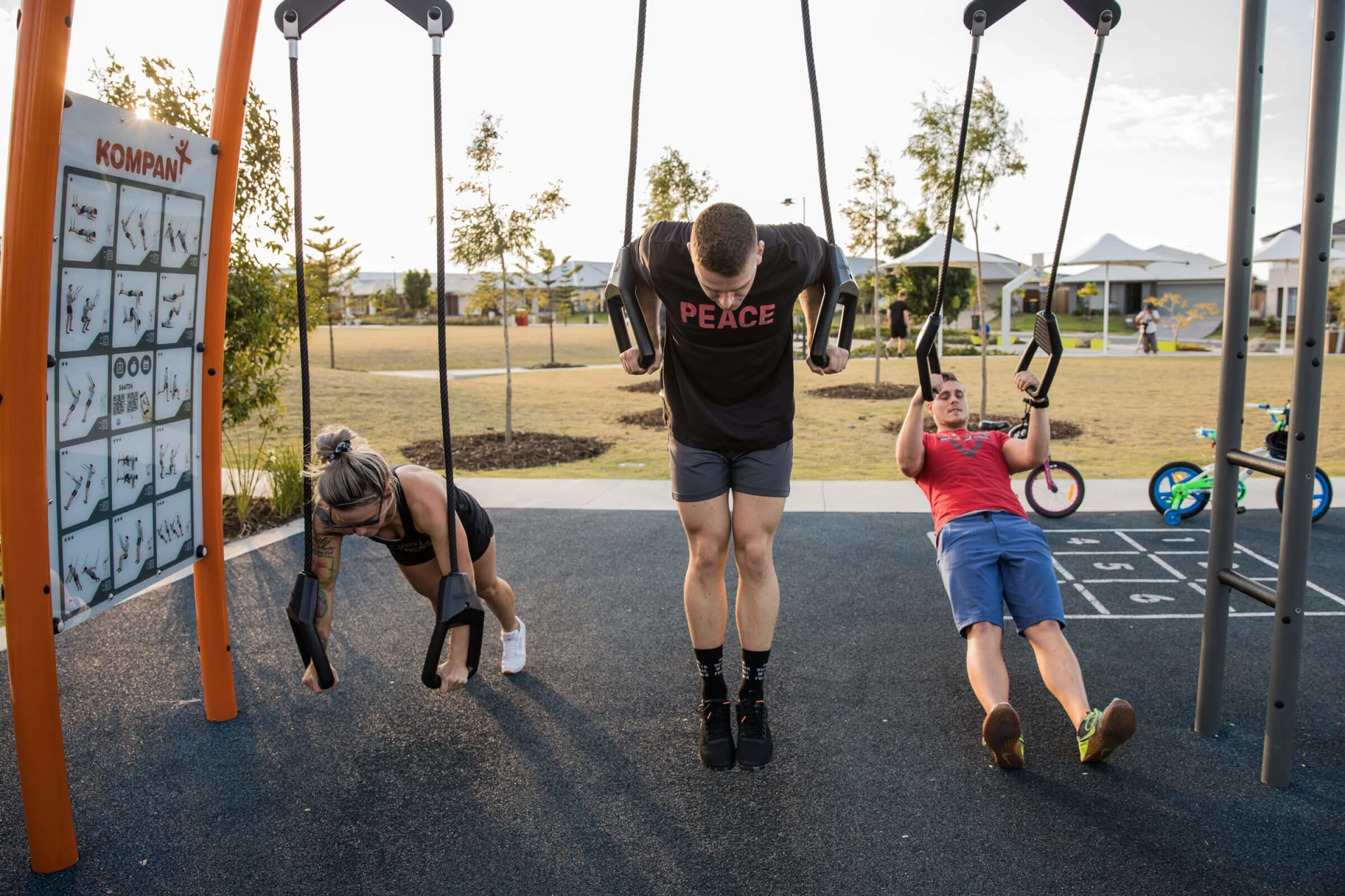 Three people working out on the suspension trainer at Capestone outdoor gym
