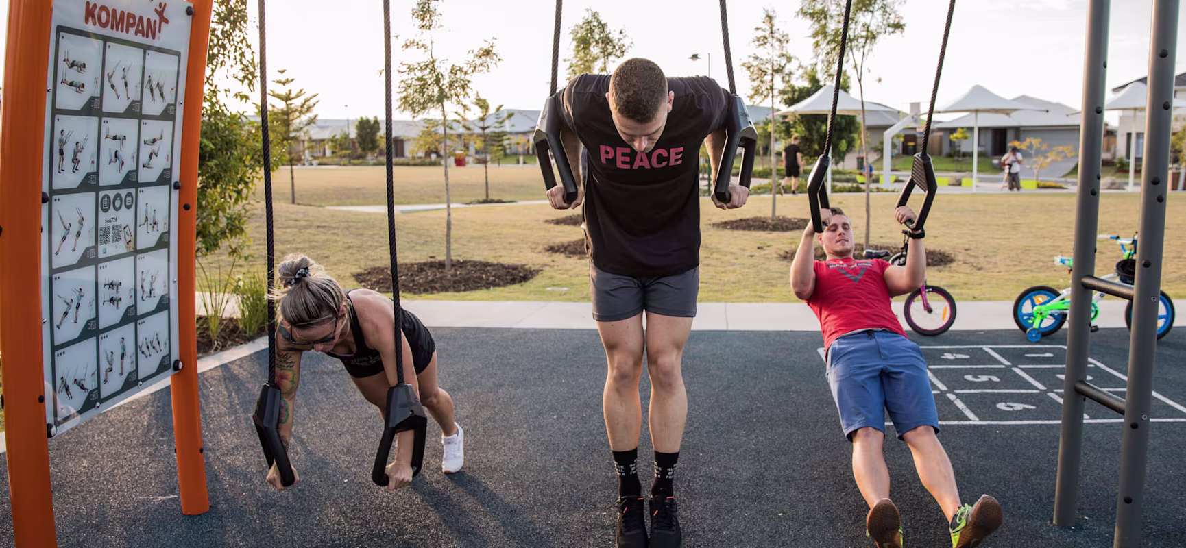 Three people working out on the suspension trainer at Capestone outdoor gym