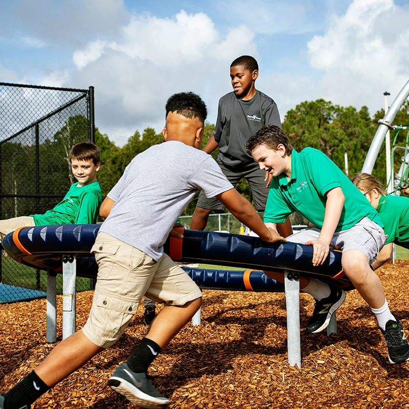students playing on the spinning supernova playground carousel