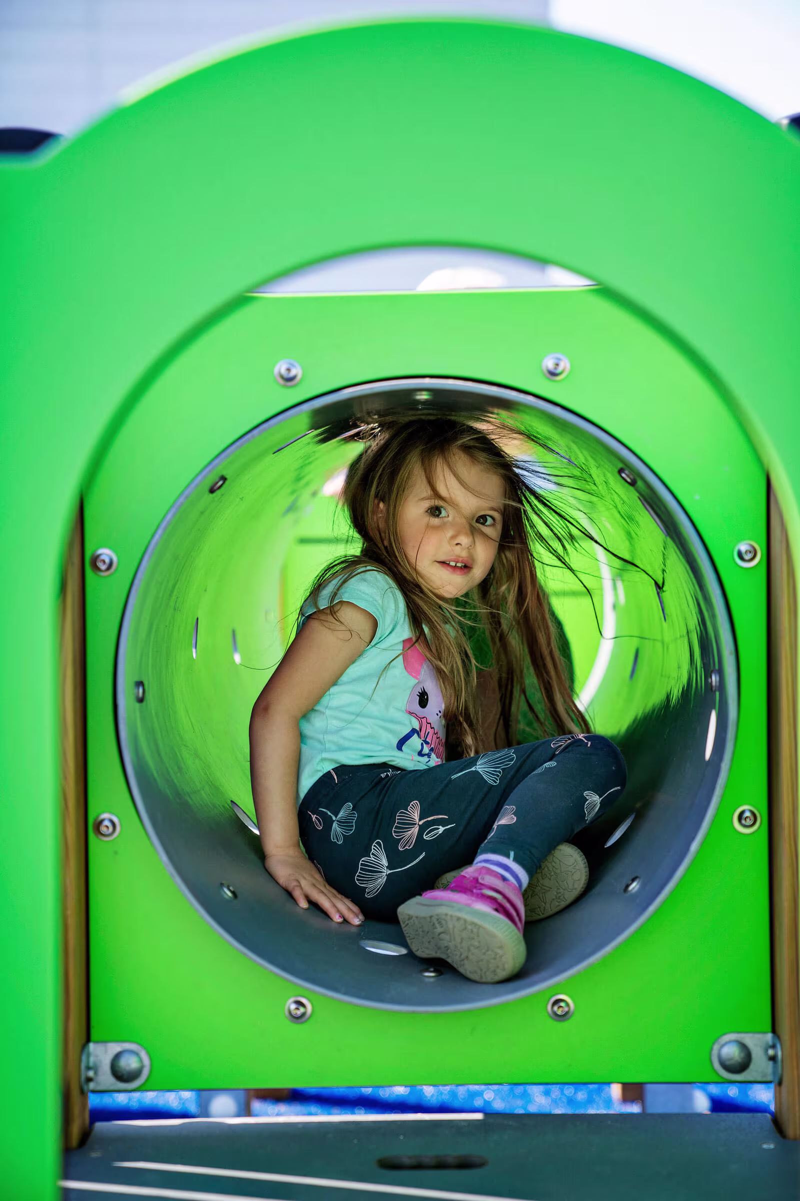 小学校の遊具でチューブに座る女子児童