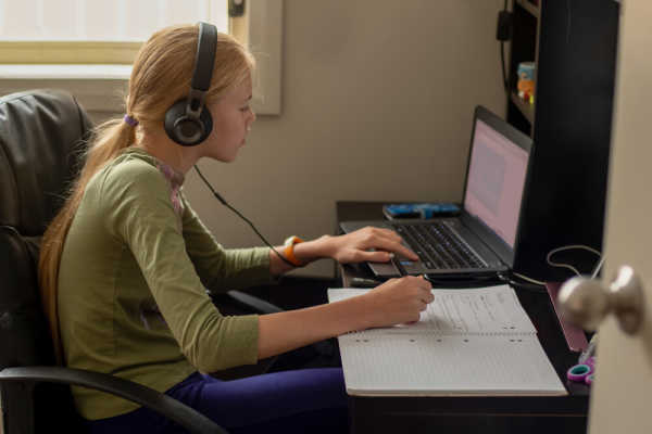 student-notetaking-computer-headphones