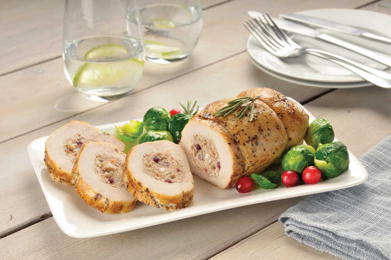 Stuffed Turkey Breast Roast on White Platter with Vegetables