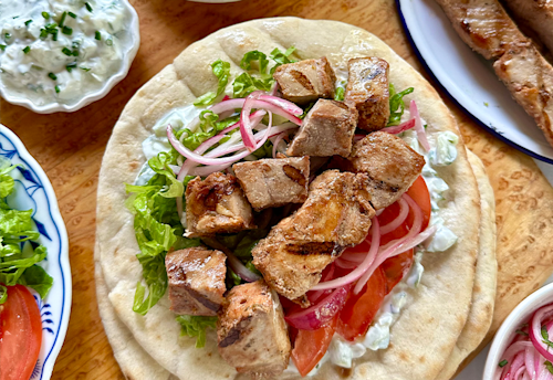 Kabobs on pita with hummus and veggies