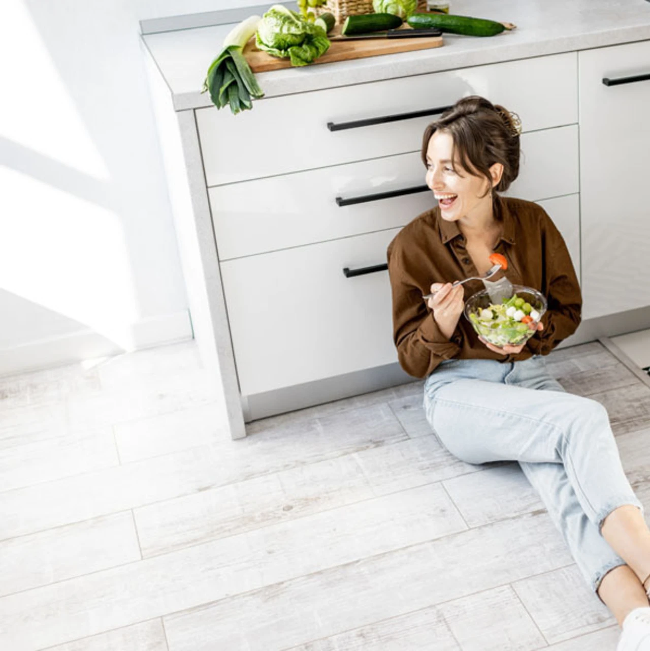 vrouw zit op vloer in keuken | femme assise sur le sol dans la cuisine 