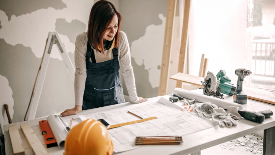 Een vrouw werkt aan een bouwproject | Une femme travaille sur un projet de construction