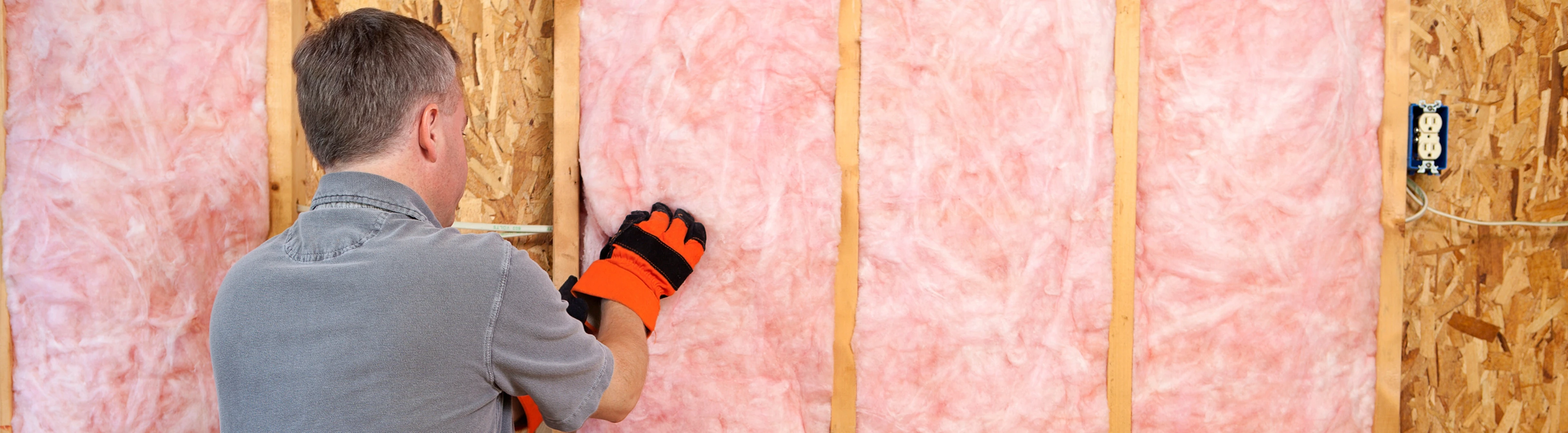 iemand installeert roze isolatie in een kamer | une personne installe une isolation rose dans une pièce