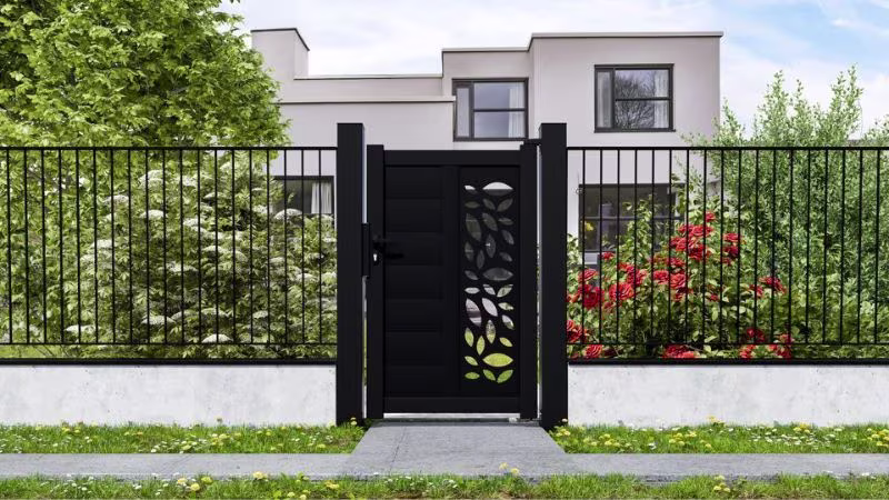 Zwarte tuinpoort met motief in metalen hekwerk voor moderne woning. | Portillon noir à motif dans clôture métallique devant maison moderne.