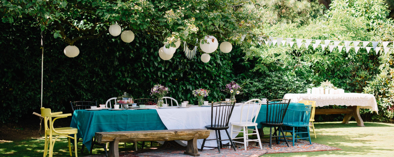 Een opgedekte tafel in het gras met slingers | Une table couverte dans l'herbe 