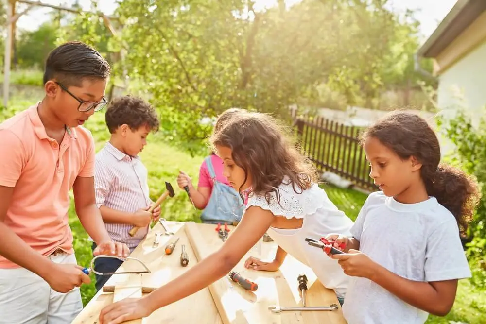 Vijf kinderen zijn aan een tafel aan het knutselen | Cinq enfants bricolent autour d'une table