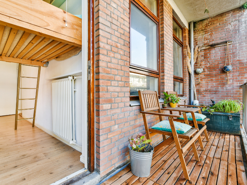 Een klein balkonnetje met twee stoelen, een kleine tafel, en planten | Un petit balcon avec deux chaises, une petite table et des plantes