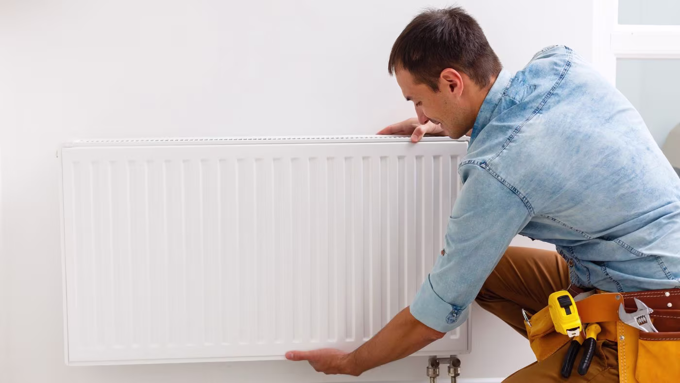 Iemand die een radiator installeert | Quelqu'un qui installe un radiateur