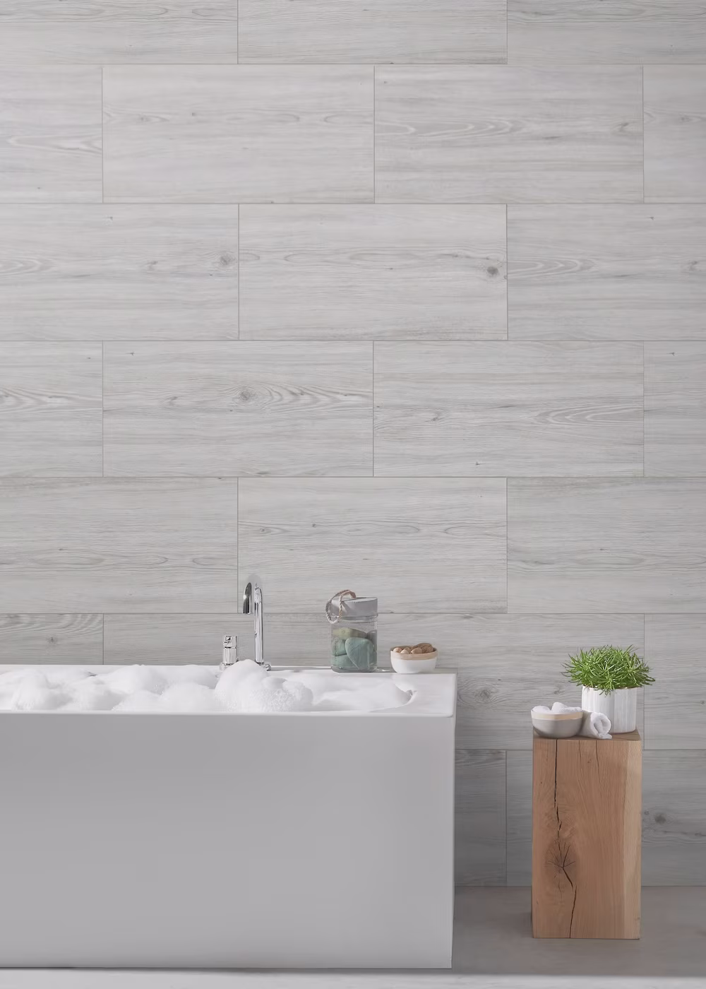 badkamer met wit bad, beige wandpanelen en een houten kruk: Praxis inspiratiepagina badkamer wandpanelen trends