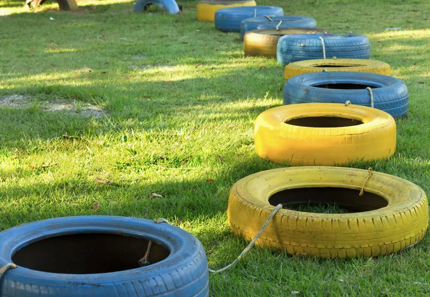 Autobanden als speelgoed in het gras | Pneus de voiture comme jouets dans l'herbe 