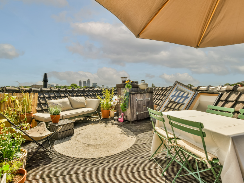 Een dakterras met zithoek en eettafel op een zonnige dag | Une terrasse sur le toit avec un coin salon et une table à manger par temps ensoleillé