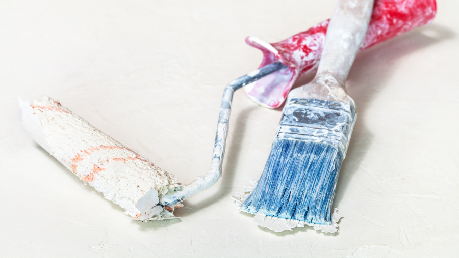 Uitgedroogde verfrollen en verfborstel op een witte achtergrond | Rouleaux de peinture séchés et pinceau sur fond blanc