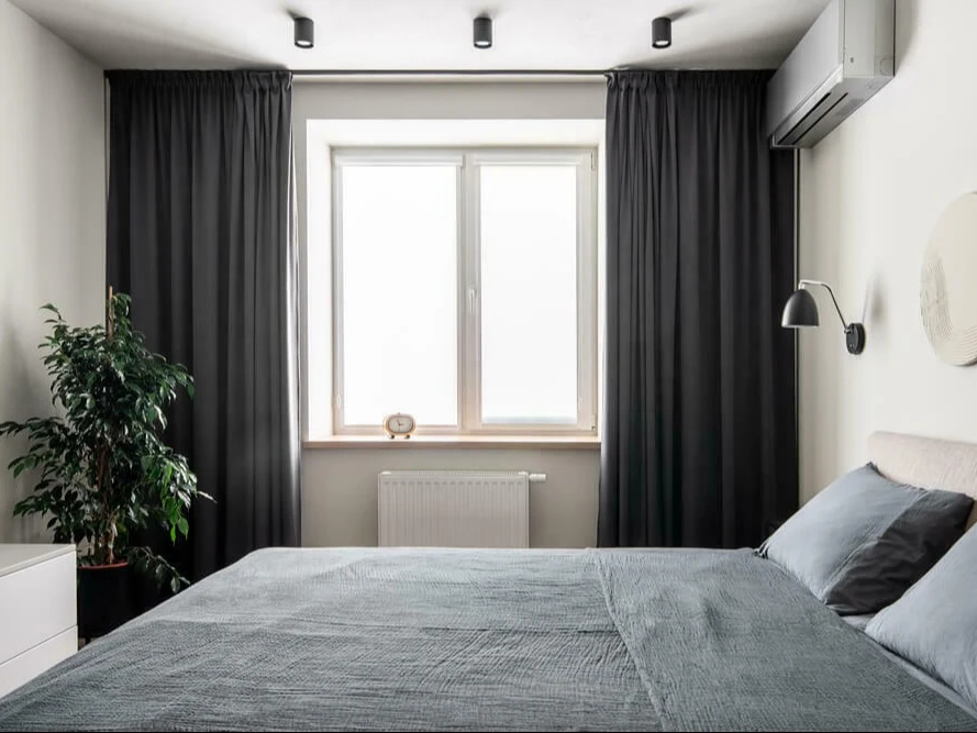 slaapkamer met grijs bed en gordijnen | chambre à coucher avec lit et rideaux gris