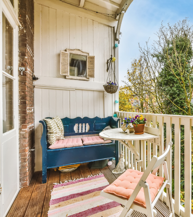 Een gezellig klein balkon met een blauwe bank en planten | Un petit balcon confortable avec un banc bleu et des plantes