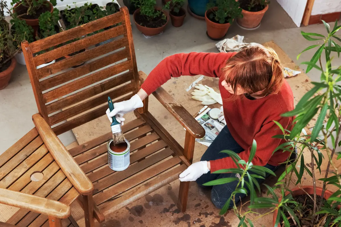 vrouw lakt stoel | une femme vernit une chaise 