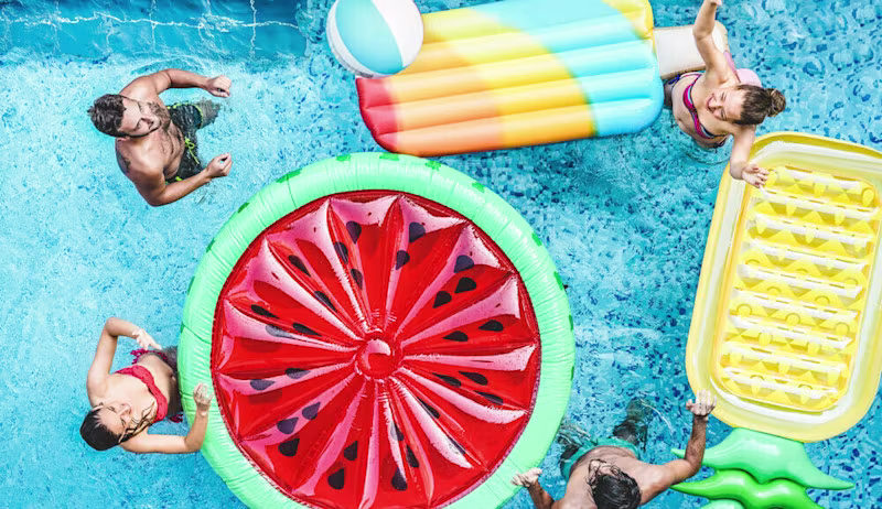 Vier personen in een zwembad met opblaasbedjes | Quatre personnes dans une piscine avec des lits gonflables